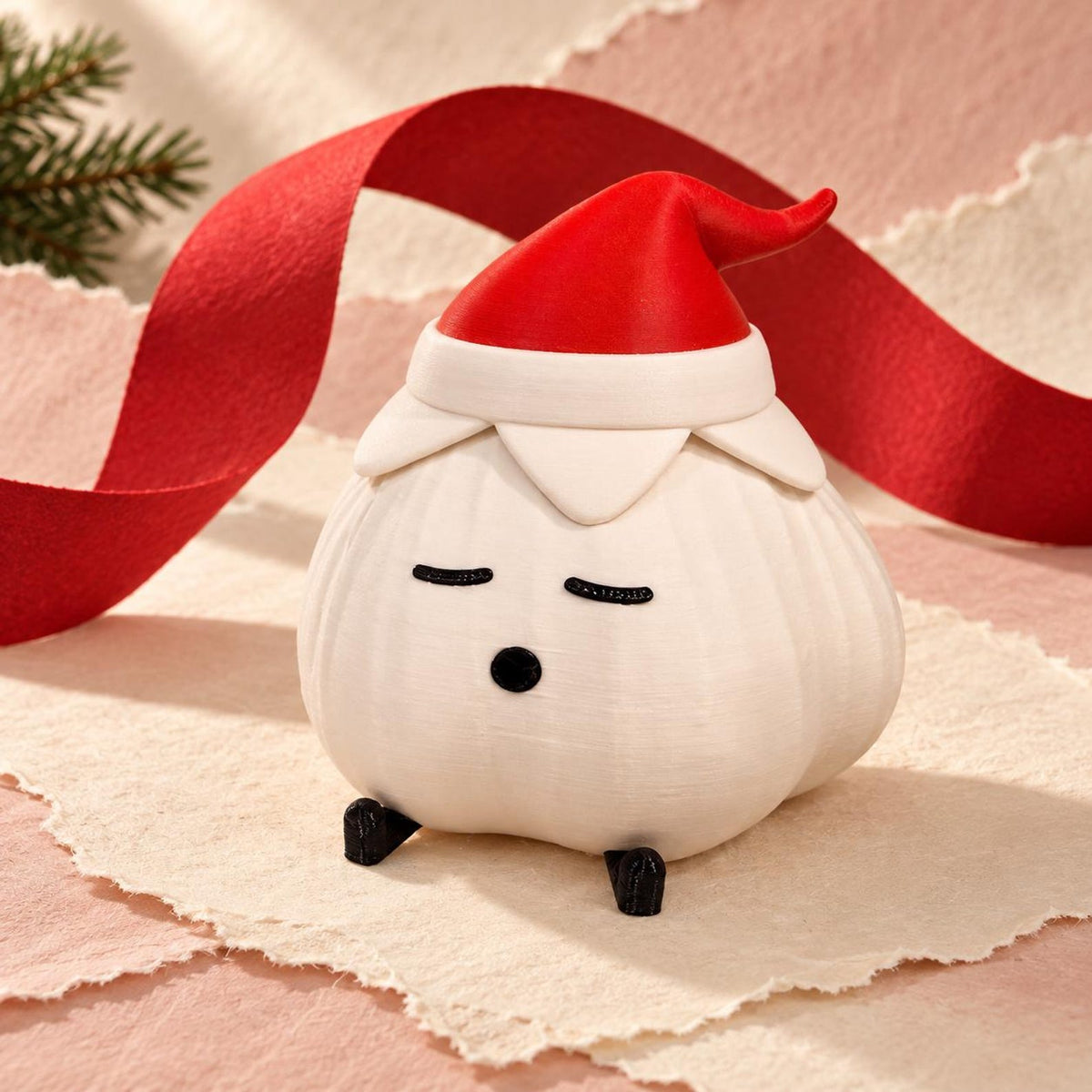 Garlic lamp with a matte ivory ridged body, red elf hat with ivory cuff and tiny black feet, on a cream lace doily with a red ribbon and pine sprig against a pink background. A cheerful christmas light shown unlit.