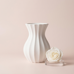White Modern Fluted Vase beside a white rose on a pale pink background