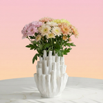 White textured vase with flowers on a light pink background