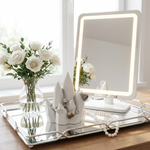 Lighted vanity mirror on a tray with flowers and jewelry
