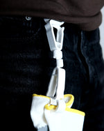 Close-up of a plastic clip attached to a piece of clothing with a white background