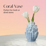 Coral-shaped vase with white tulips on a light pink background