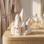 White jewelry holder with gold necklaces on a wooden surface