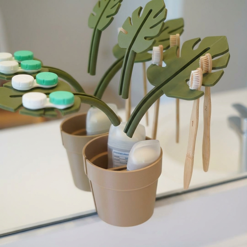 Dental care products including toothbrushes and toothpaste in a decorative pot with leaf-shaped holders.