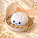 Smiling white dumpling lamp, a cute night light and kawaii decor piece, in a steamer basket with chopsticks on warm peach paper with soft sunlit shadows and tiny flowers.