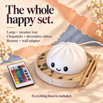Dumpling lamp ad reading 'The whole happy set': a white kawaii night light in a steamer basket with chopsticks beside a color remote, noting everything listed is included.