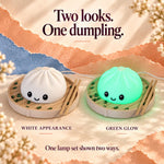 Dumpling lamp ad reading 'Two looks, one dumpling': one white and one glowing green dim sum night light, each in a steamer basket with chopsticks, a cute foodie gift.