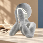 Marble NObody Lamp beside an open book and eyeglasses in warm sunlight