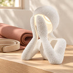 White NObody Lamp beside a peach yoga mat and tea cup