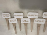 White and beige plant markers labeled African Violet, Lavender, Cilantro, Sage, Dill and Parsley