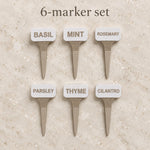 Six white and beige plant markers labeled Basil, Mint, Rosemary, Parsley, Thyme and Cilantro