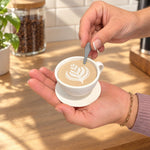 Small white coffee cup container held in two hands