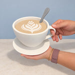 White cup-shaped storage container held against a light blue wall