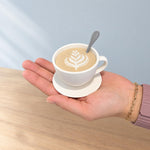 Small white coffee cup storage container held in a hand