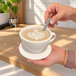 Spoon placed into the removable latte-art lid of a white coffee cup container