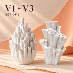 Two white matte textured coral-style vases with the text "V1 + V3 SET OF 2": a tall tubular bud vase on the left and a wider, ruffled sculptural vase on the right.