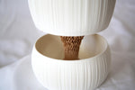 Angled close-up of the white Pallas pot, tan textured core and matching reservoir bowl