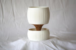 Empty white Pallas planter and matching reservoir bowl on draped white fabric