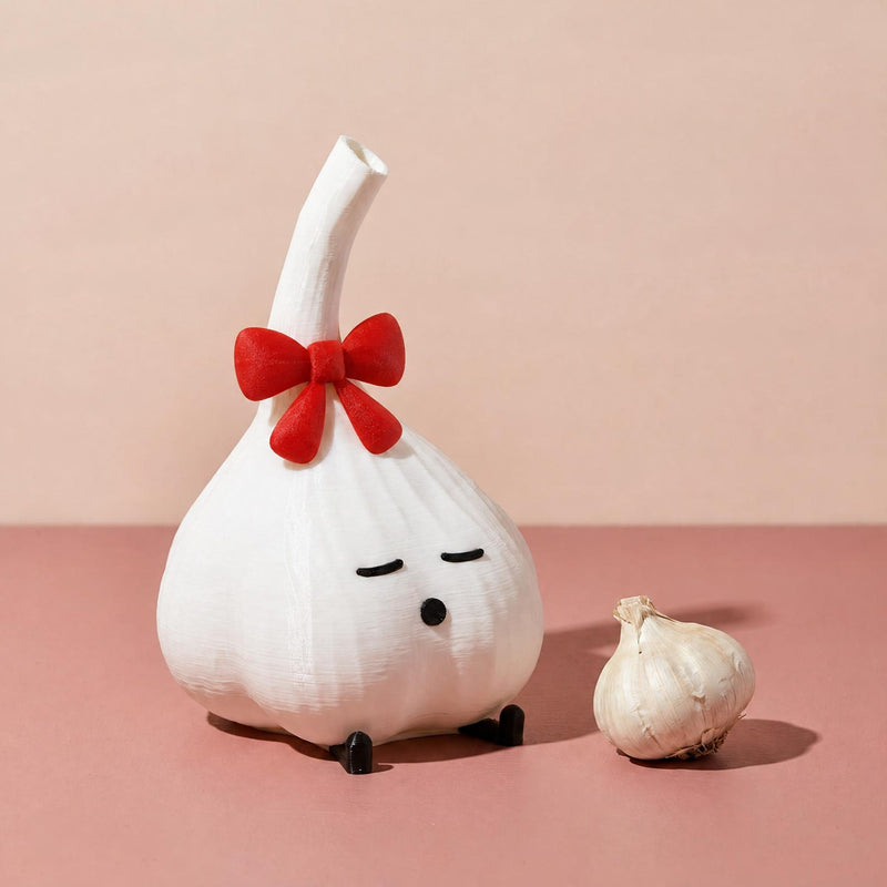 White garlic lamp with a red bow beside a garlic bulb