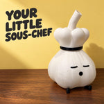 Garlic lamp in a chef hat on a wood table