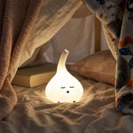 Warm glowing garlic lamp tucked into a blanket with a book
