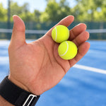Two tennis ball clickers resting in an open palm
