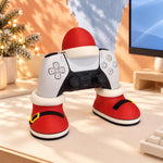 Santa controller stand on a gaming desk beside a monitor and keyboard, red Santa boots with yellow buckles and a Santa hat holding a controller, gaming desk decor and stocking stuffer. Controller not included.